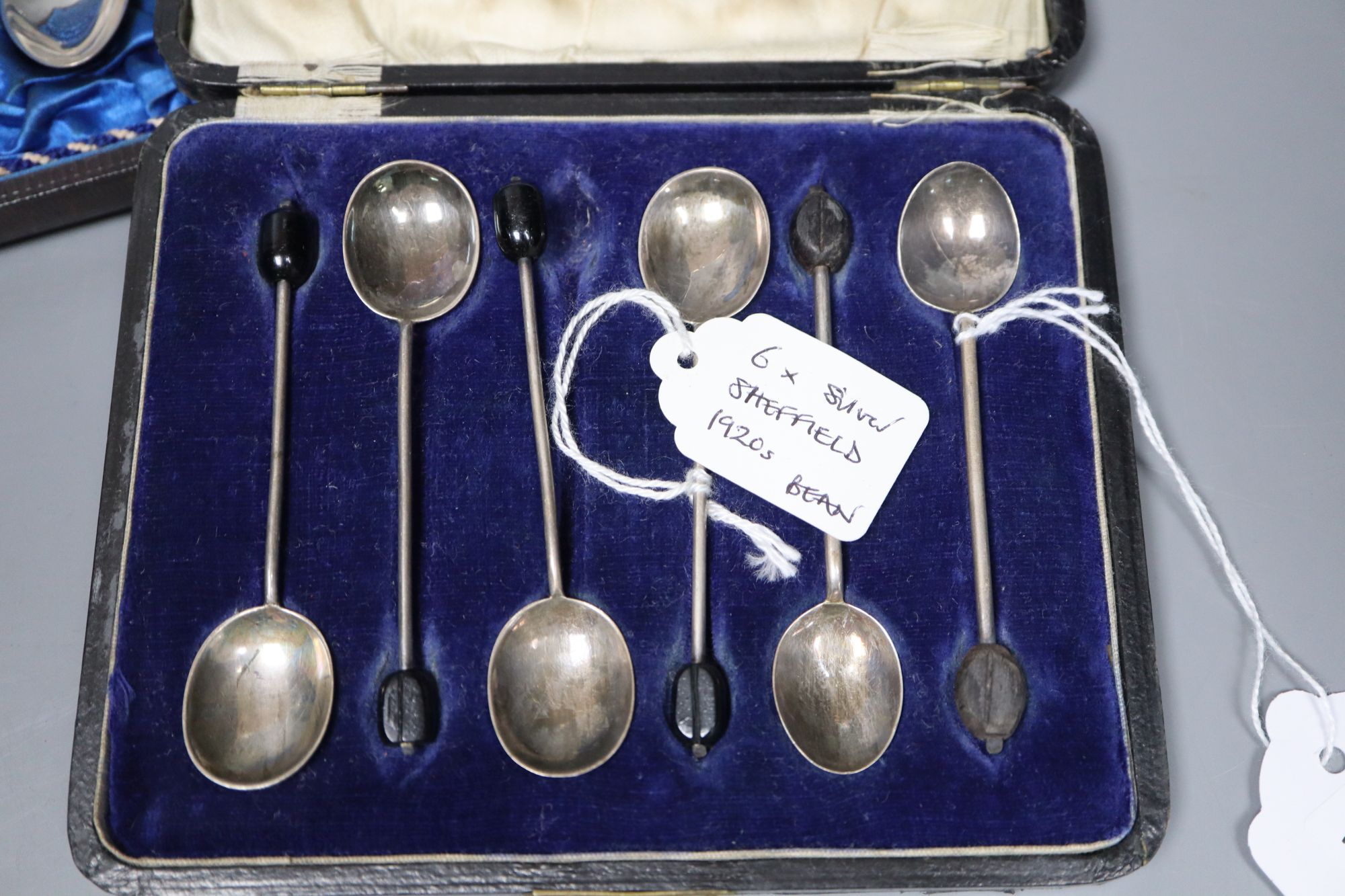 Twelve Victorian silver Apostle coffee spoons and sugar tongs, and three sets of six silver bean end coffee spoons, all cased